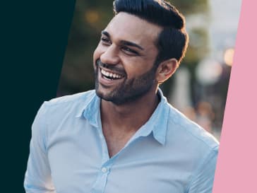 A man in professional attire smiling warmly while looking upwards.