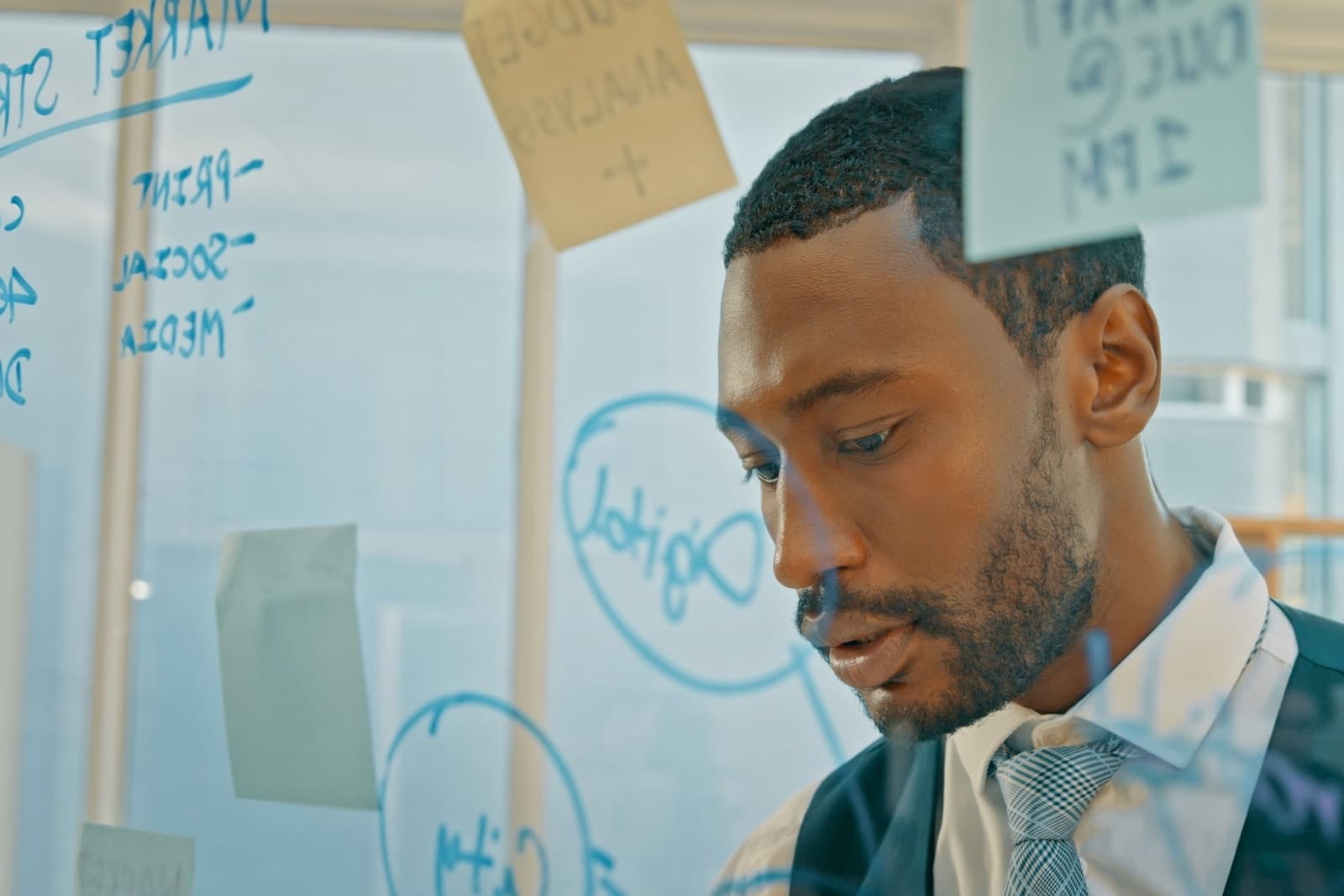 Man looking at a wall of notes.