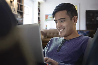 Man sitting at laptop and smiling